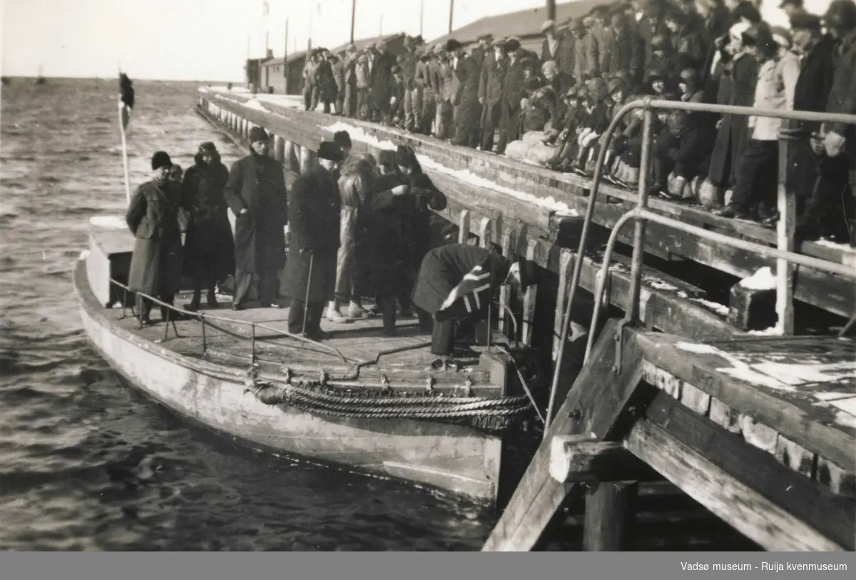 Kronprinsparets besøk i Vadsø i 1934. De kongelige kommer til kai i Vadsø med liten båt. Masse folk på kaia.
