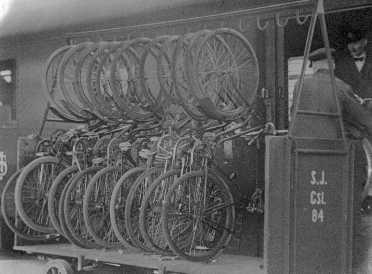 Cyklar upphängda på en vagn vid centralstationen. 
Vagnen har texten: SJ Cst. 84.