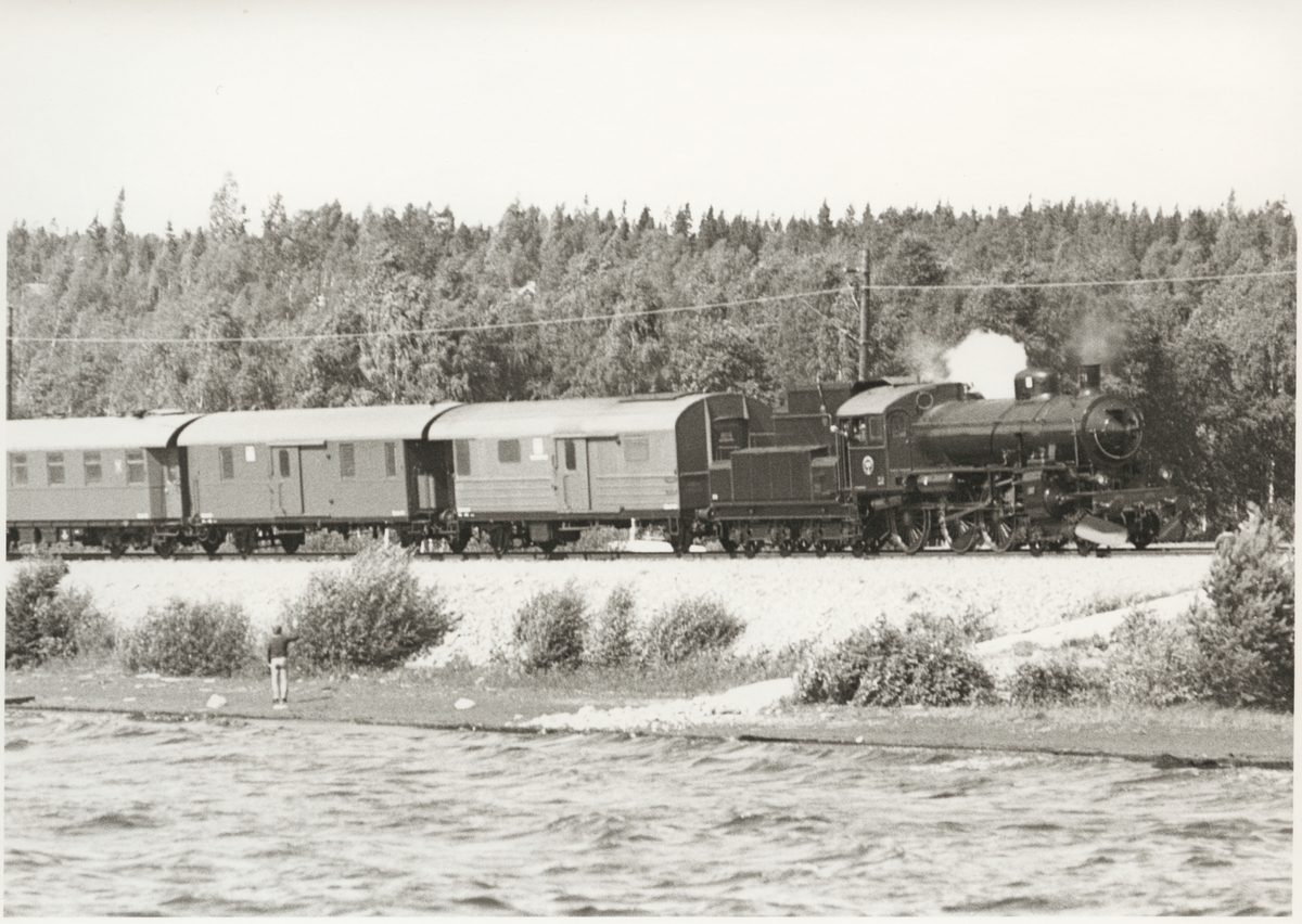 Statens Järnvägar, SJ B 1371.

Tåg med ånglok och vagnar vid del av Siljan.