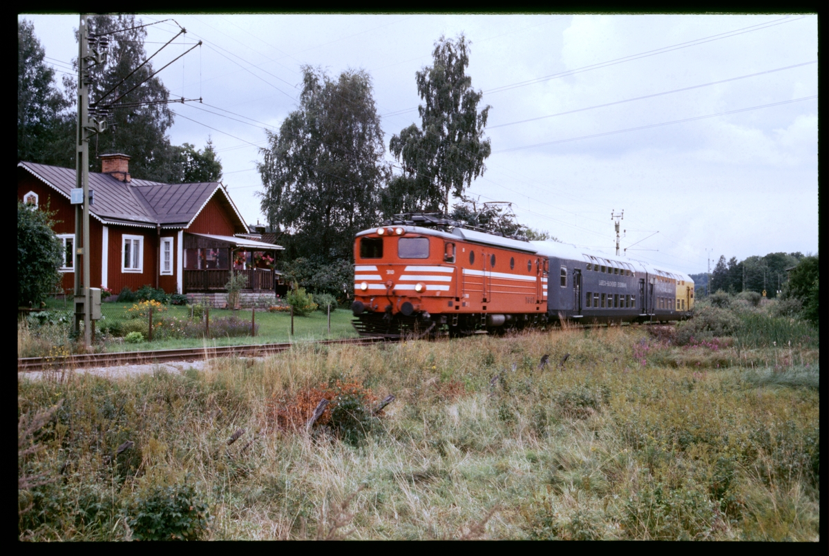 Forssa banvaktstuga nr 606 på sträckan mellan Taxinge-Näsby och Hedlandet. Trafikaktiebolaget Grängesberg–Oxelösunds Järnvägar, TGOJ ellok med personvagnar.