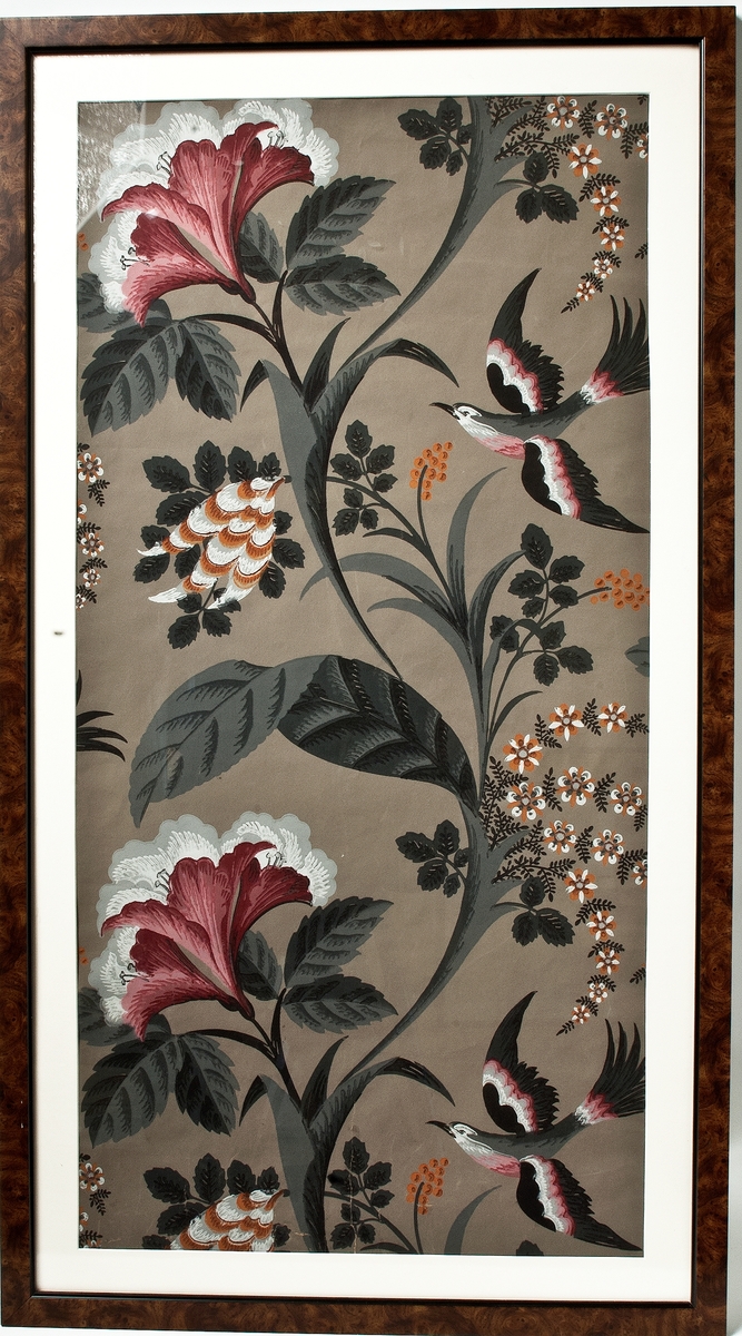 Tapet med storskaligt mönster av blomrankor och fåglar i grått, vitt, svart, rosa och ockragult på gråbrun bestruken botten. Nio tryckfärger. IB
Inramad.