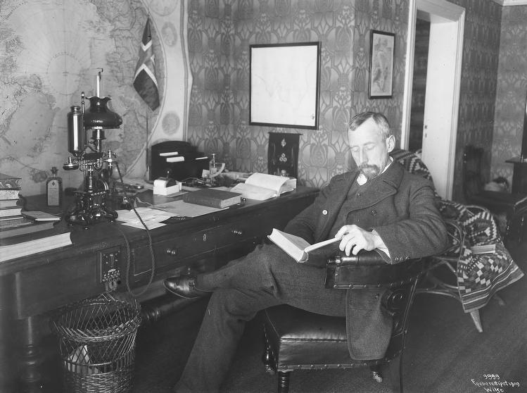 Roald Amundsen sitter og leser på sitt eget kontor i Uranienborg. (Foto/Photo)