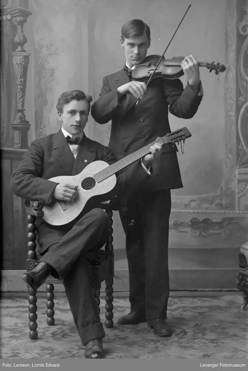 Portrett av to menn som spiller gitar og fiolin.