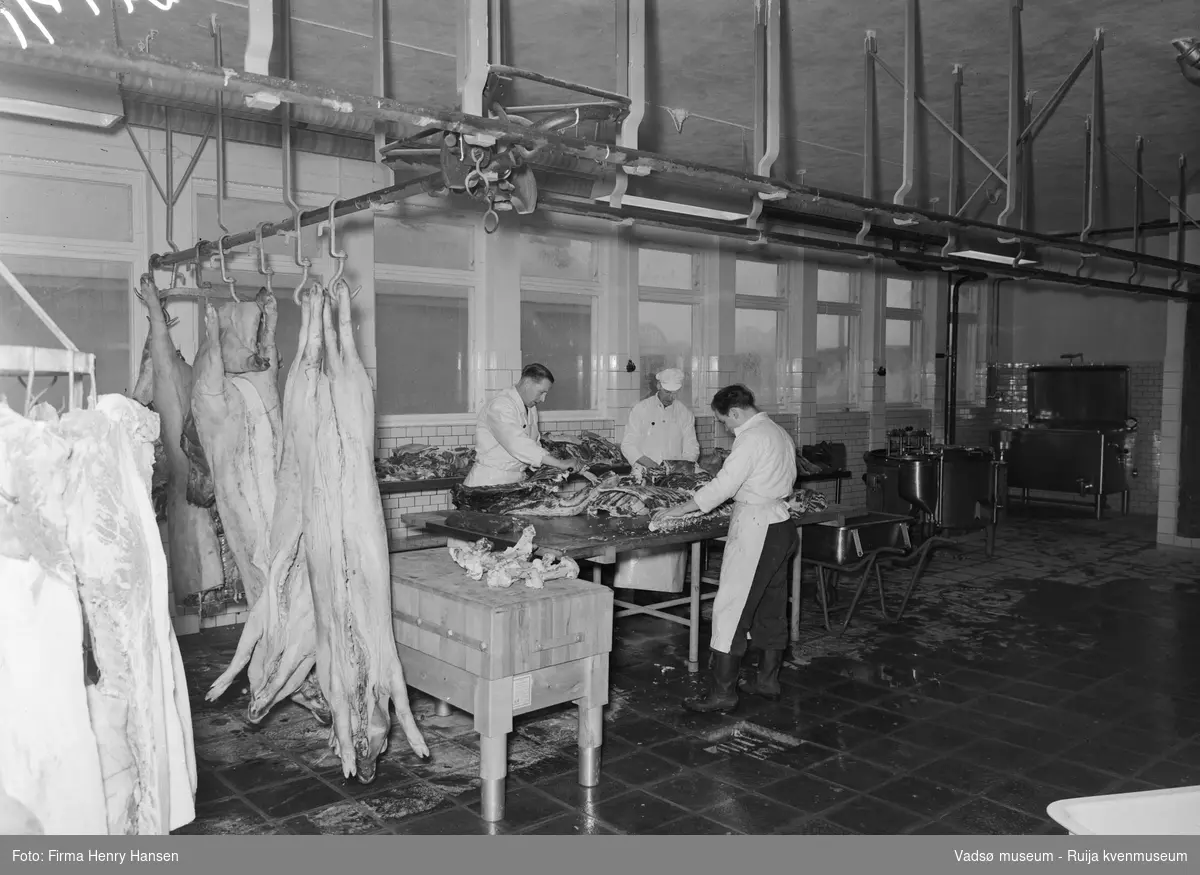 Nord-Norges salgslag produksjonslokaler i Vadsø, 1957. Partering av slakt pågår.