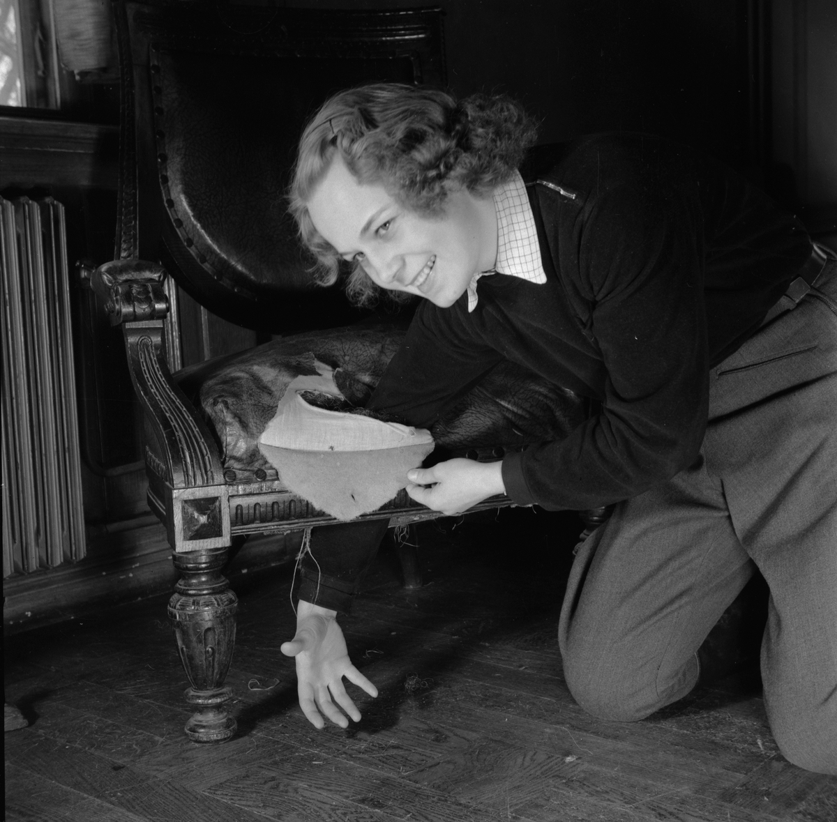 Kvinna med trasig stol, Östgöta nation inför restaurering, Uppsala 1946