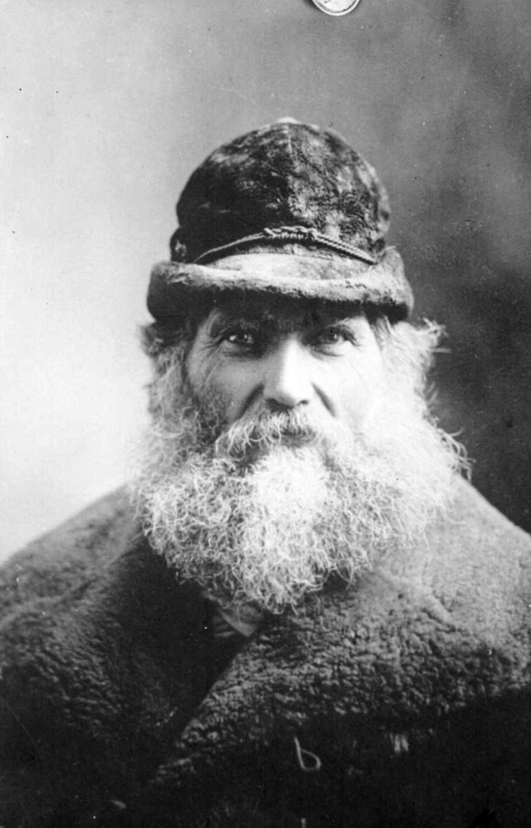 Portrett av eldre mann med stort skjegg.