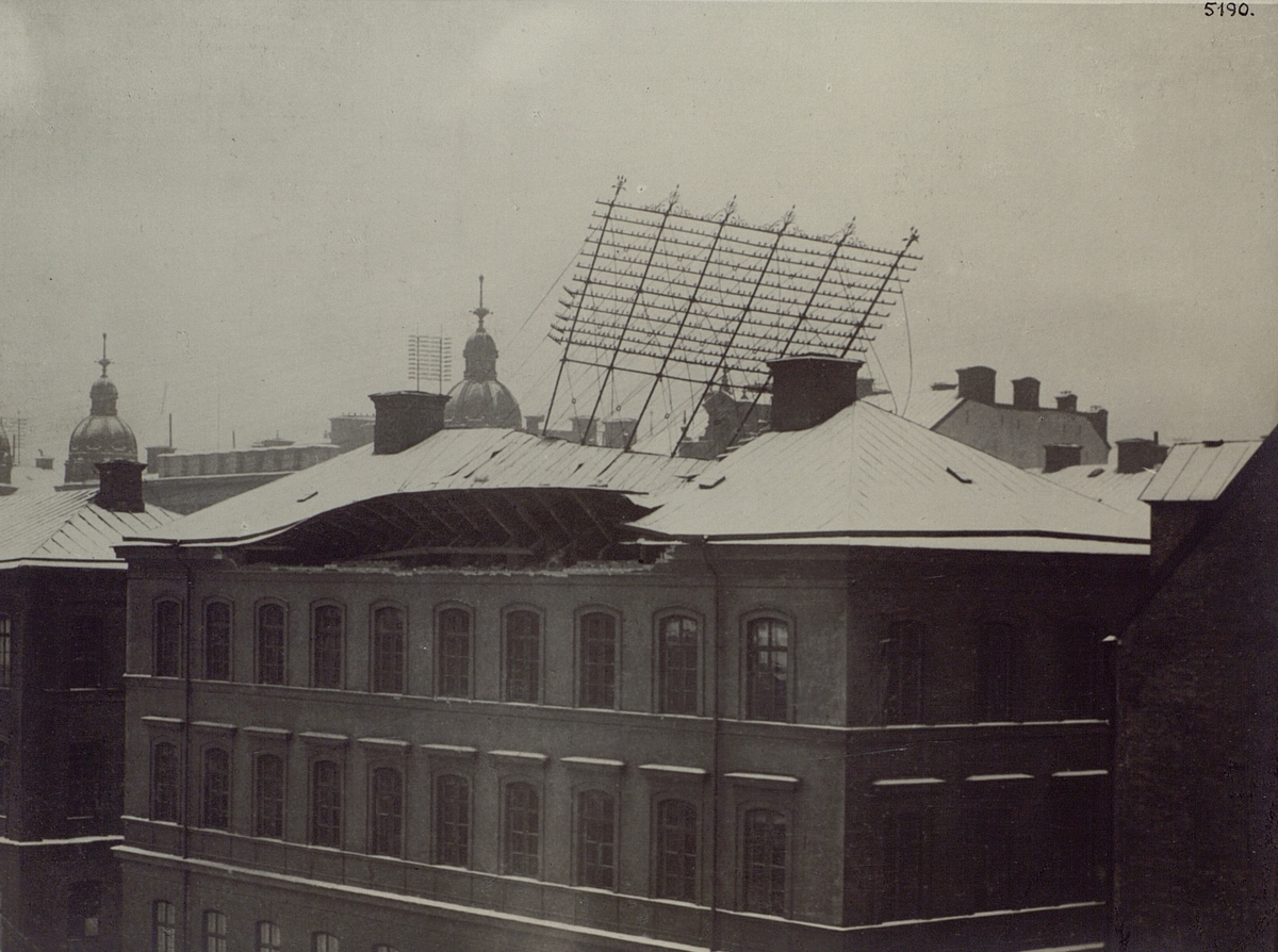 Troligen Stockholms Allmänna Telefonaktiebolags stora telefongalge på dåvarande Klara folkskola, Vasagatan 13, har tagit med sig hela taket vid sitt fall. Nyårsdagen år 1897.