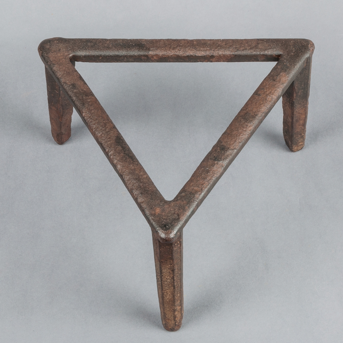Grytfot av järn, trekantig, likbent triangel.
Tre fötter. Längd i sidan: 24 cm.