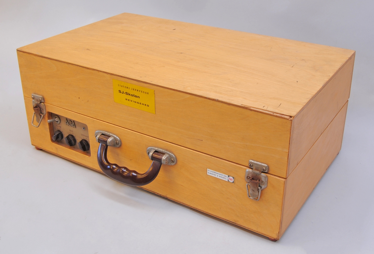 Resegrammofon tillverkad av Almqvist & Wiksell under 1960-talets första år. Grammofonen är av väskmodell med rektangulärt kabinett i ljus plywood med bärhandtag i brun bakelit. Undersidan av kabinettet har luftningsslitsar urfrästa i plywooden. I det avtagbara locket finns en högtalare bakom grått tyg. 

Skivspelaren är remdriven och placerad till höger i kabinettet samt har ett chassi av gråmålad plåt med rundade kanter. Armen är av svart bakelit som hålls på plats med ett enkelt spänne vid transport och bredvid armen finns ett svart bakelitvred för inställning av uppspelningshastigheten. Skivtallriken är av metall och har en matta av grått gummi.

Till vänster om skivspelaren finns förstärkardelen som är rördriven och har ett ventilerat chassi i gråmålad plåt. Reglagen är åtkomliga från kabinettets framsida och består av en vippströmbrytare samt tre vred i brun bakelit för volym, bas och diskant. Över vreden finns AGA:s logotyp. Till vänster om förstärkaren finns ett fack för ström- och högtalarkabel.
