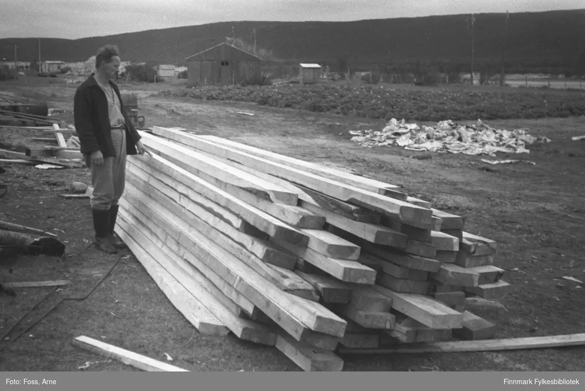 Gjenreisning er i gang i Tana, byggematerialer ligger i bakken, august-september 1946.