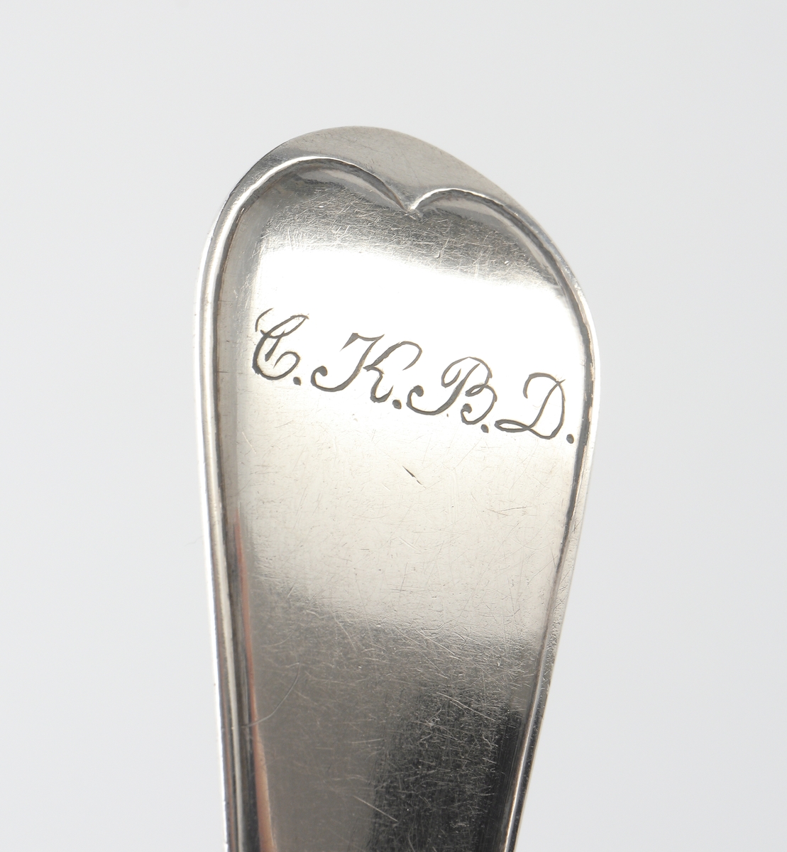 Matsked i silver.
Trubbig svensk modell. Ägarinitialer: "C.K., B.D." på baksidan av skaftet. Stämplar på baksidan av skaftet.