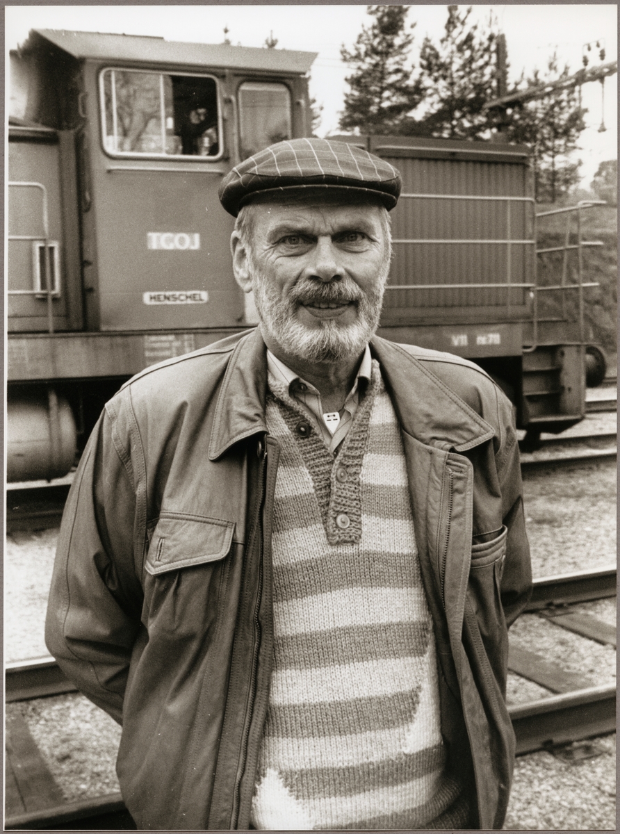Karl-Erik Svedlindh pensionerad lokförare vid Trafikaktiebolaget Grängesberg - Oxelösunds Järnvägar, TGOJ i Oxelösund. Bakom Karl-Erik står TGOJ V11 711.