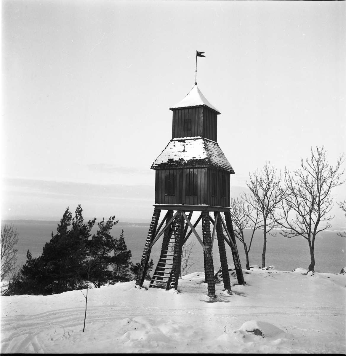 Klockstapeln vid friluftsmuseet på Grännaberget. Det är vinter med snö på marken.