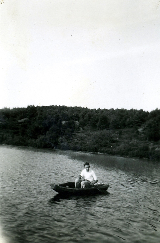 Bo Ericson (1930 - 2011) ror en liten eka på Fisjön, 1940-tal. Fisjön ligger väster om Labacka i Kållered.
