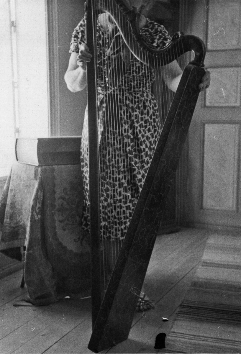 Harpe av ukjent opprinnelse fra første halvdel av 1700-årene. En ukjent kvinne holder harpen.