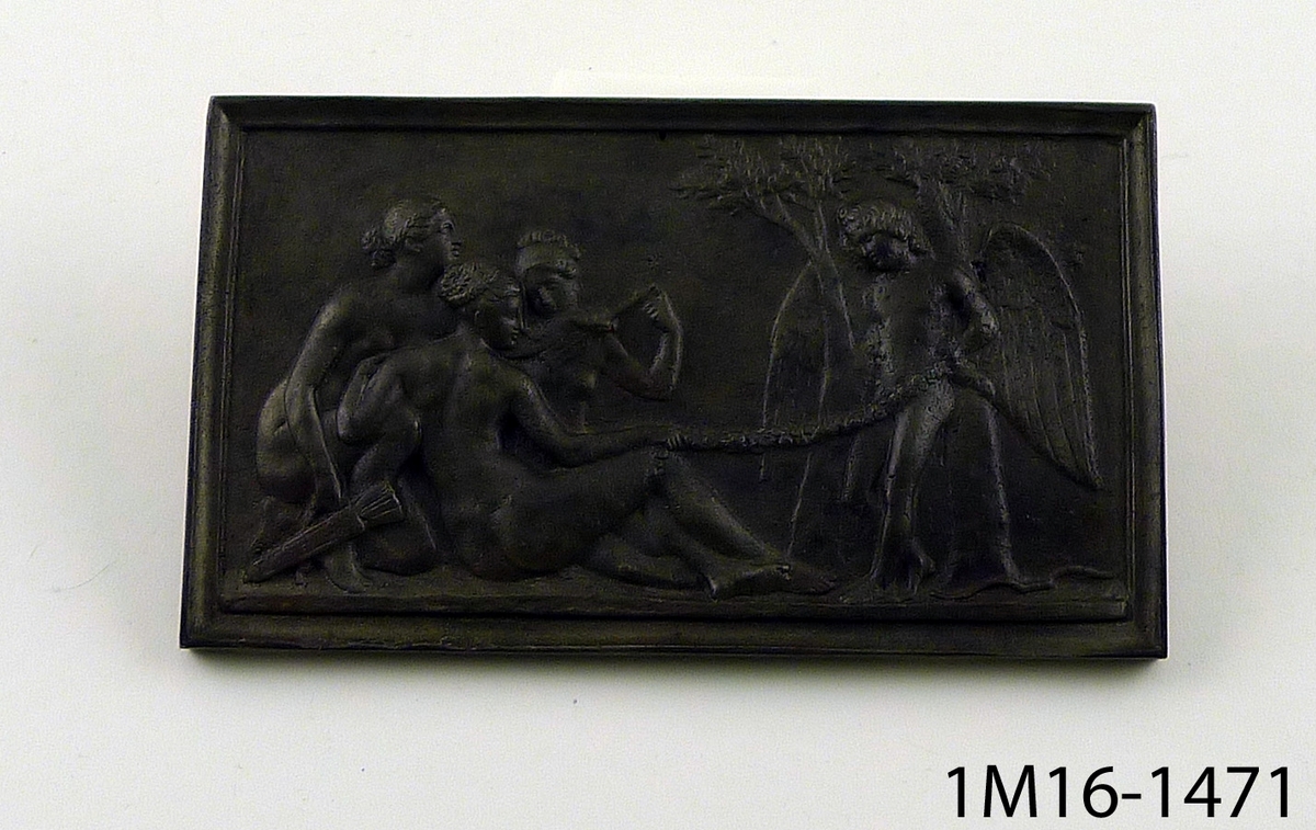 Relief av järn, rektangulär, föreställande guden Amor och framför honom tre sittande kvinnor (troligen de tre gracerna), i bakgrunden två träd.