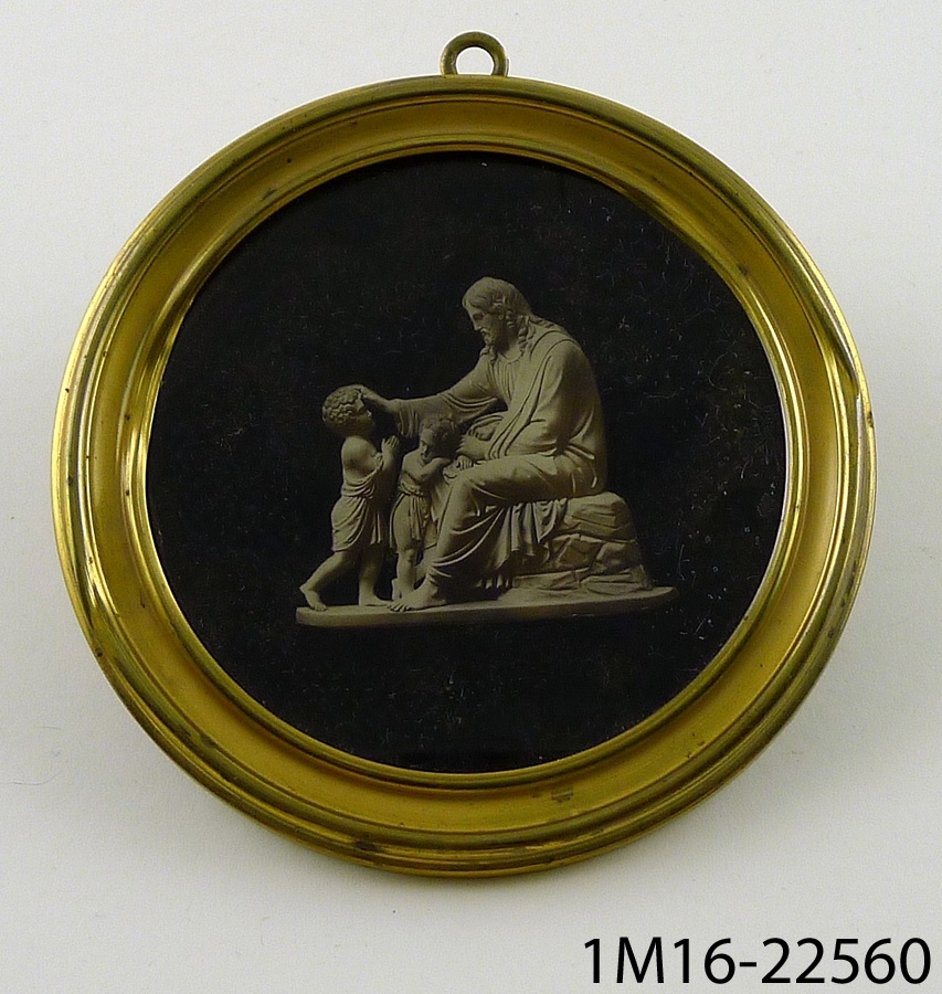 Tavla: medaljongform, med slät mässingsram, med insatt foto av en skulpturgrupp: "Frälsaren välsignar herren."