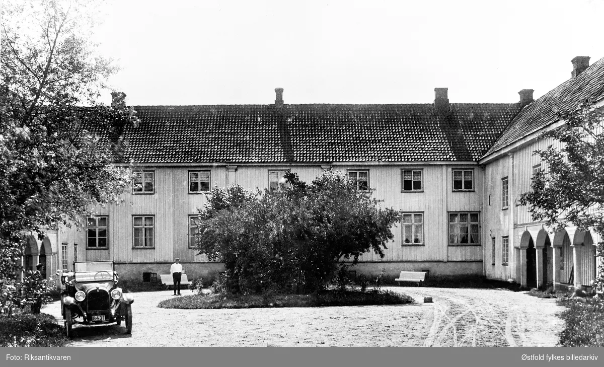 Elingård, herregård i Onsøy, hovedbygningen sett fra gårdsrommet, bygningen er fredet og eies av Fredrikstad kommune og driftes av Fredrikstad Museum (2019). Bil med kjennetegn B-431. Ukjent mann.
