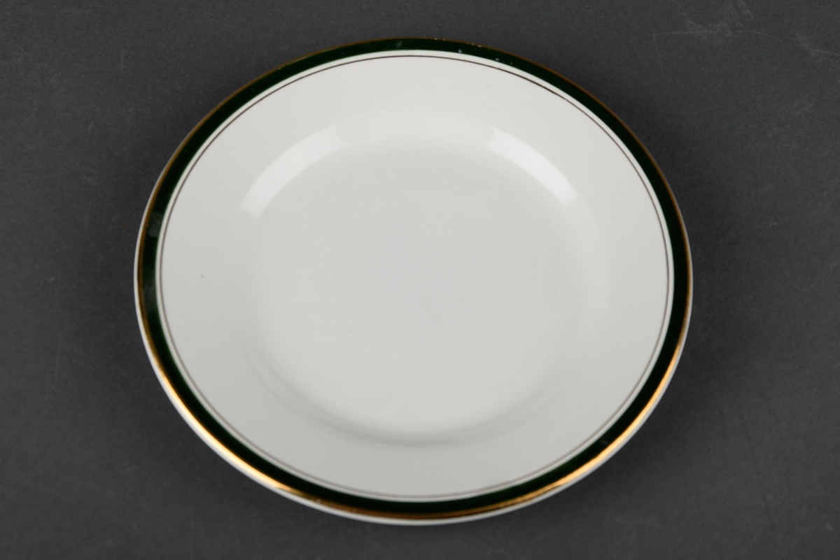 1 hvit tallerken, dekorert med en grønn og gull sirkel langs kanten.