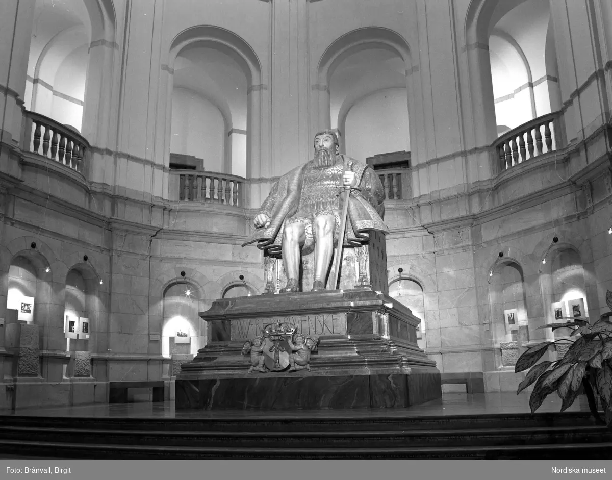 Dokumentation av Nordiska museets utställning Barnets Århundrade 26/1 1992 – 1/11 1992.  Staty av Gustav Vasa gjord av Carl Milles. Två småpojkar tittar på fotografier.