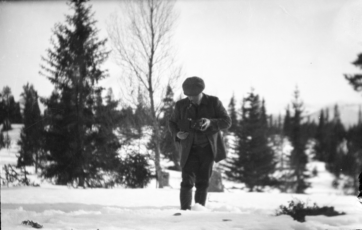 Mann som tar bilde i snøen