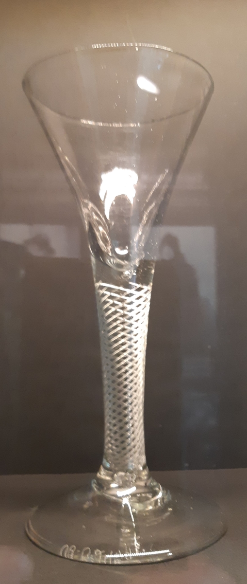Coctailglass med stett, av klart glass. Stetten er tykk og har et spiraliserende rutemønster på innsiden.
