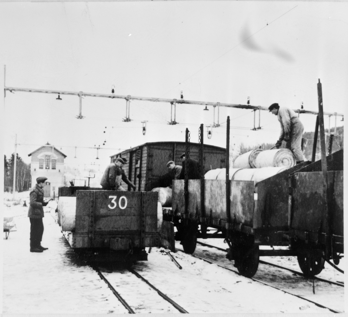 Omlastning av gods mellan godsvagn på normal spår och godsvagn 30 på smalspårig järnväg.
