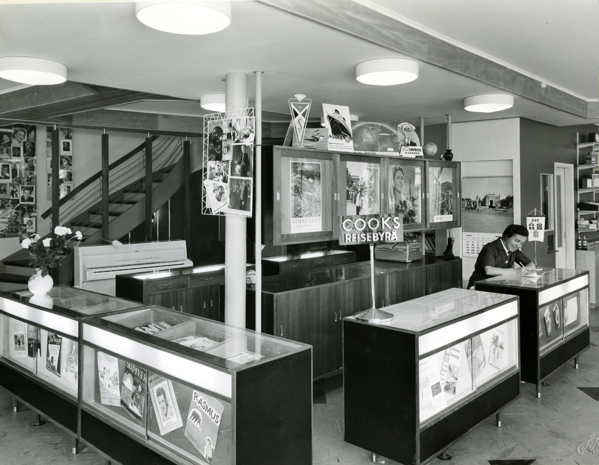 Ingeborg Ranum bak disken i Cooks reisebyrå avdelingen i Olaf T. Ranums musikkhandel. Til venstre er disken for salg av notetrykk.