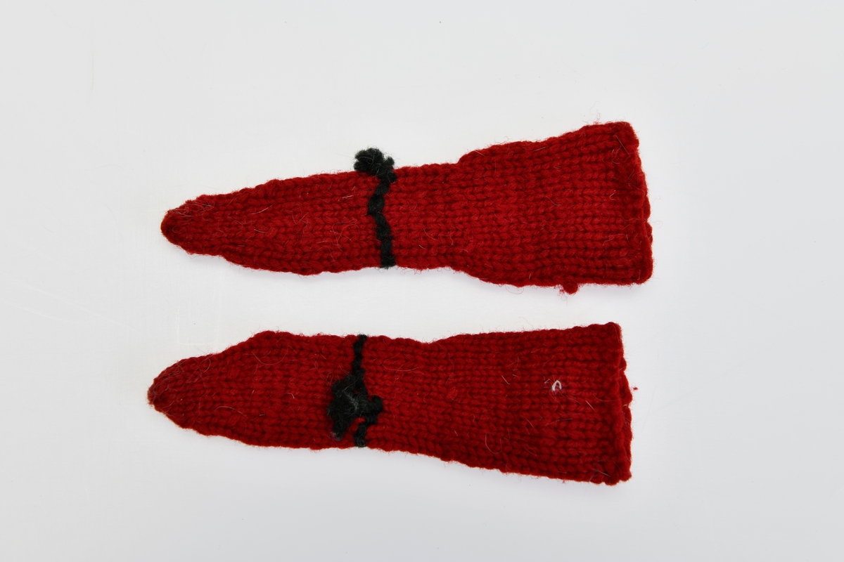 Et par strikkede ullsokker til dukke. De er strikket med rødt ullgarn i rettstrikk. På leggen er det brodert et fiskebeinsmønster med svart ullgarn. Ankelen er markert med en enkel brodert bord. På hver av sokkene er det en liten svart dusk ved ankelen.
