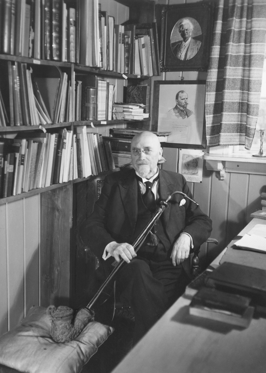 Repro: Foto av Anders Sandvig på sitt kontor, med pipe, og bilde av B. Bjørnson og H. Aall bak seg