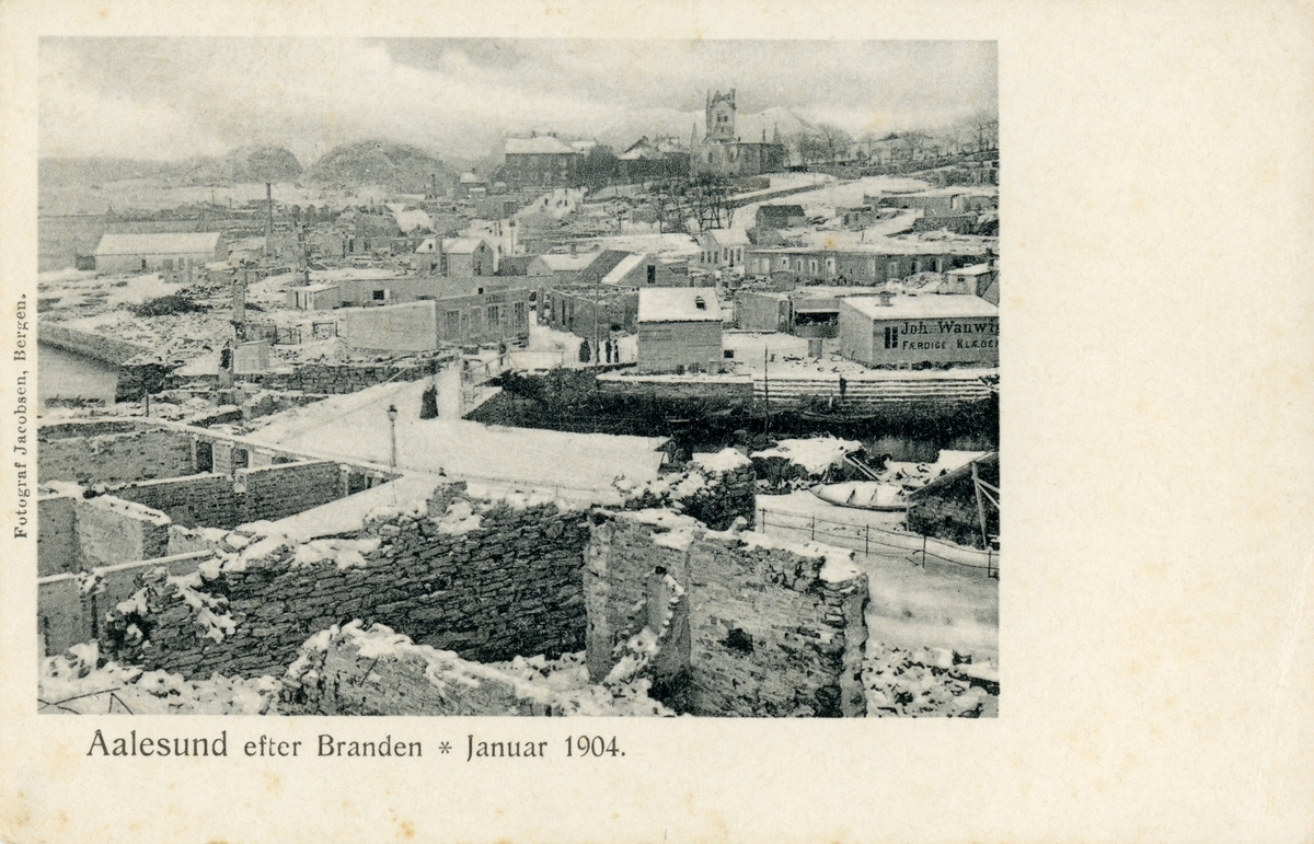 Oversiktsbilde av Brosundet og Aspøya med kirka i bakgrunnen. Ålesund står fortsatt i ruiner etter bybrannen, men flere barakker/brakker er kommet opp.