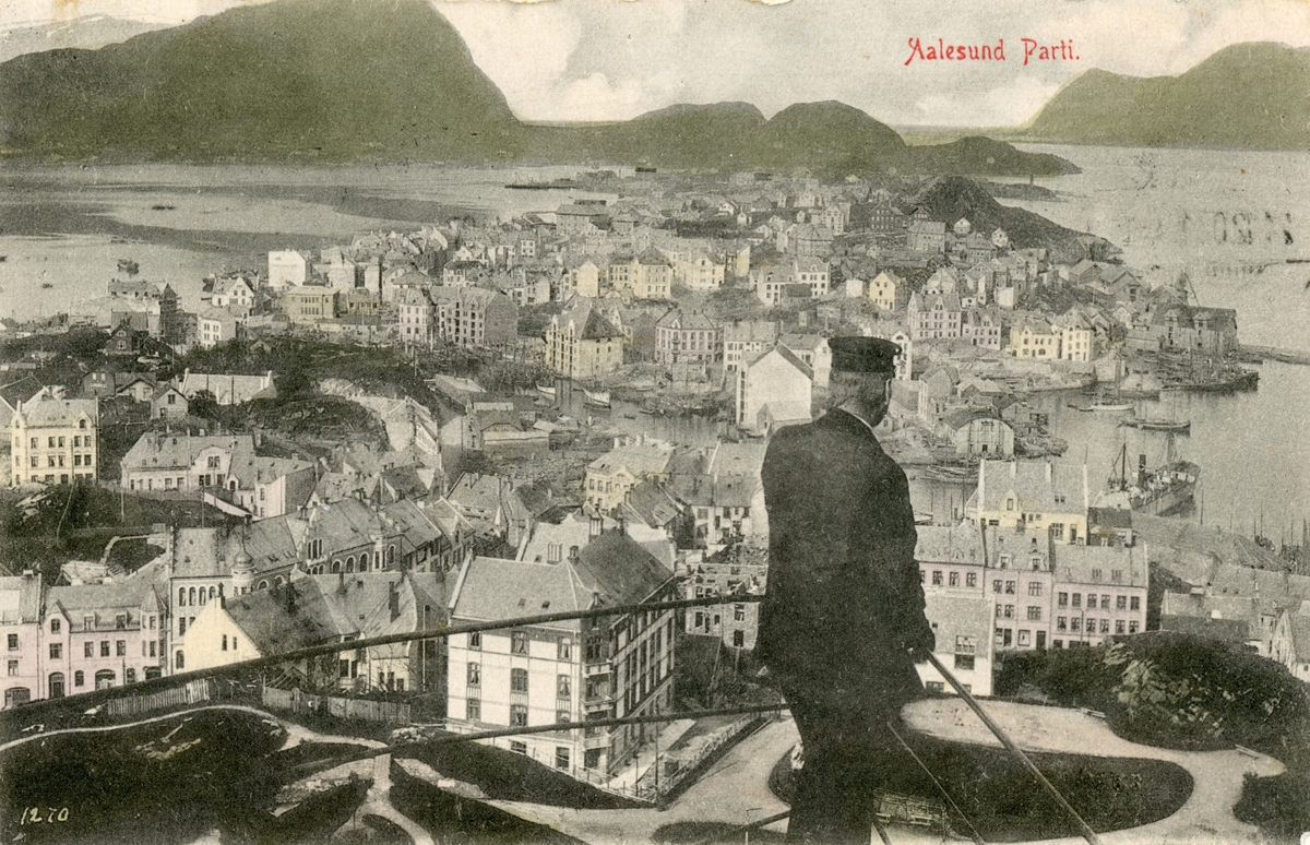 Oversiktsbilde av Ålesund by og parken. I forgrunnen står en mann med uniform i trappene opp mot Fjellstua.