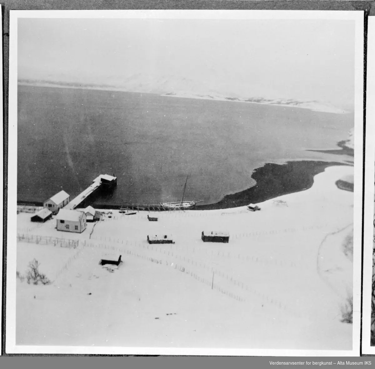 Utsikt over handelen på Kviby vinteren 1942 med en båt på land og en snødekt kai.
