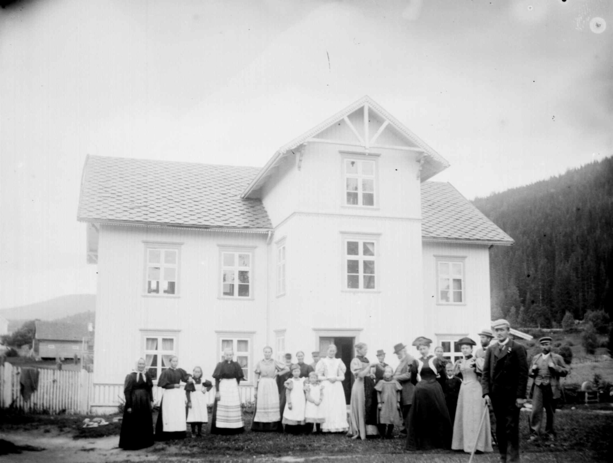 Gruppe folk utenfor hus på Bjørnstad gård, Biri. Antatt det er Nordre Bjørnstad