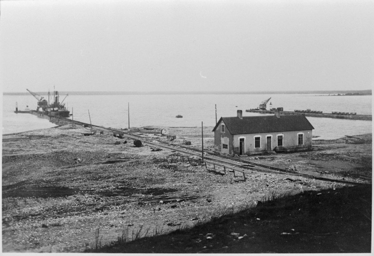 Ångbåt och hamnkran vid Bungenäs hamn. Magasinbyggnad till höger i bild.