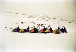 Gruppe med mennesker på fjelltur med snøskuter samlet på rek
