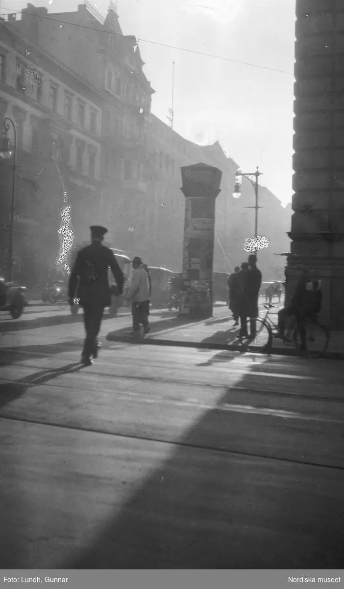 Motiv: Utlandet, Berlin 114 - 146 ;
Gatuvy med kvinnor och män som går på en trottoar, anteckningar på kontaktkarta 126 "Siegessäule monumentet" 128 "Leipziger strasse".