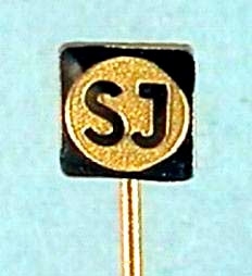 Tre kavajnålar av guldfärgad metall med SJ:s logga i rundel inom svart fyrkant.