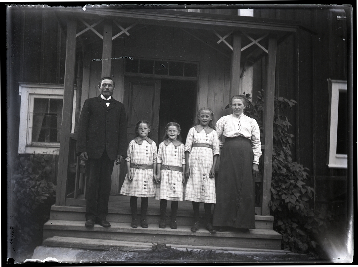 Familj, par med tre flickor på veranda.