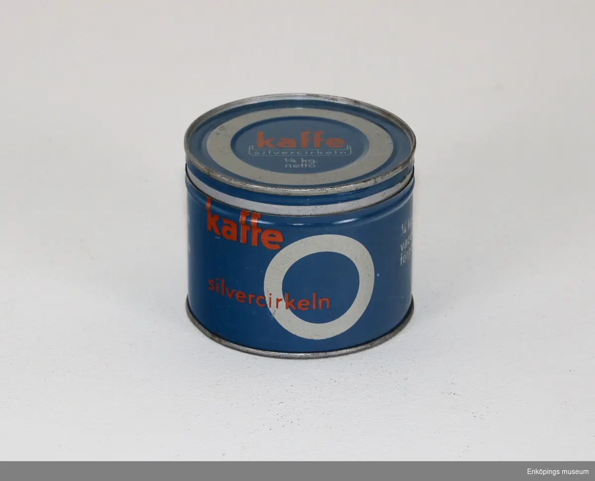 Rund blå kaffeburk med texten: "Kaffe silvercirkeln kopperativa kaffe rosterierna 1/4 kg. netto vacuum förpackat".