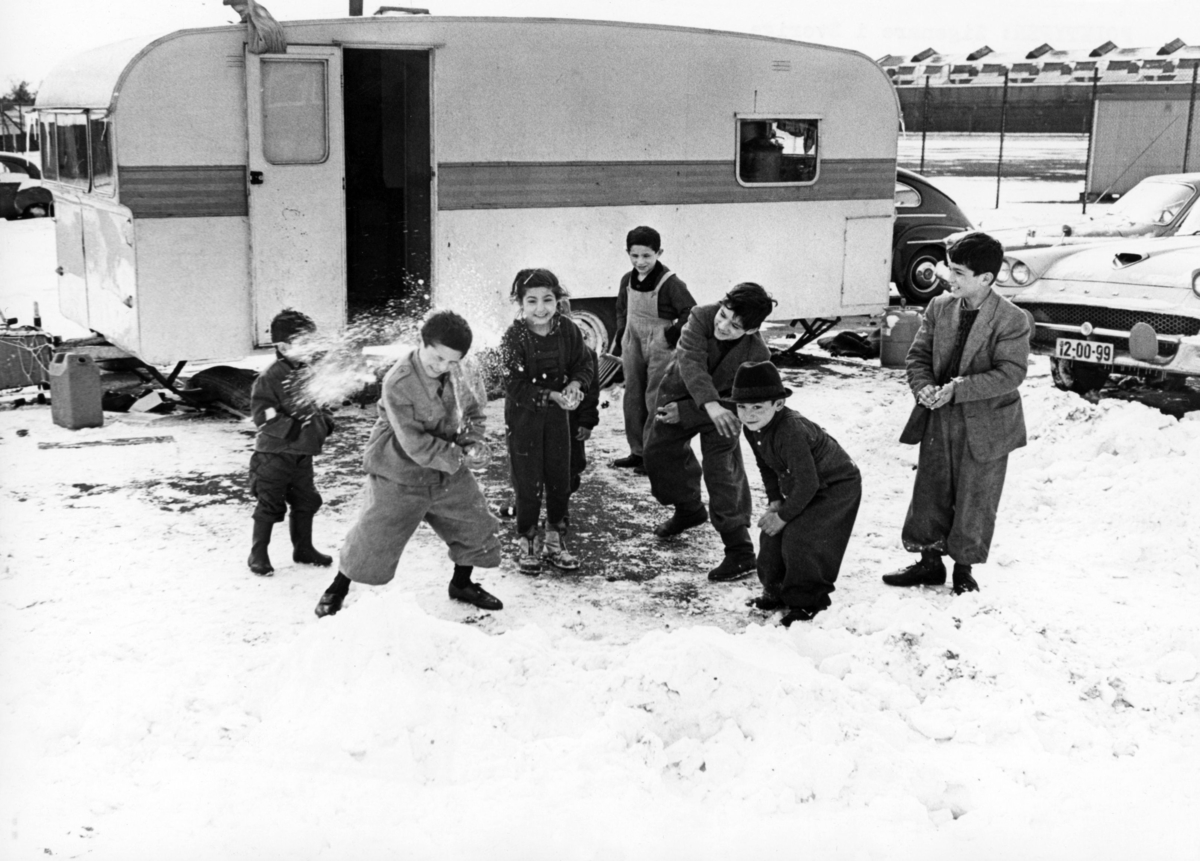 Romska barn i ett av de sista lägren i Sverige 1965. Efter att de svenska romerna i Sverige erkändes som medborgare år 1952 uppstod debatt kring gruppens svåra levnadsförhållanden. En statlig utredning genomfördes under 1954-1956 där en av slutsatserna blev att fast bostad var nyckeln till att lyckas med skolgång och arbetsliv. Efter att även Stockholm stad genomfört en utredning (1955-57) upprättades två lägerplatser vid Flaten, samt en försöksverksamhet med provisoriska bostäder i Hammarbytäppan. Tanken var att romerna skulle bo här tills dess att bostadsfrågan löstes. De två lägerplatserna vid Skarpnäck låg med omkring 2 kilometers mellanrum. De kom att benämnas Ekstubben respektive Skarpnäckslägret. Skarpnäckslägret stod färdigt för inflytt i oktober 1959 och Ekstubben stod färdig för inflyttning 15 mars 1960. Lägren skulle finnas under en övergångsperiod innan fasta bostäder ordnats, men i realiteten drog bostadsfrågan ut på tiden och lägren blev kvar i fem år. Detta trots att kommuner från och med mars 1960 hade möjlighet att rekvirera statsbidrag för kostnader i samband med romers bosättning.