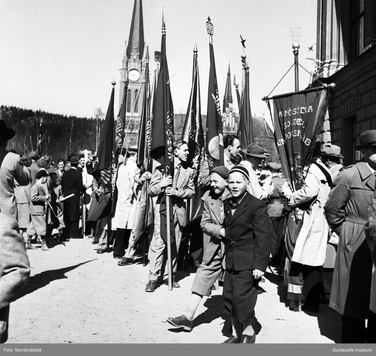 Stor bildserie från 1 maj-demonstrationer 1950 med samling och talare vid läroverket, demonstrationståg med blåsorkester, hästeskort, plakat och fanor in mot Storgatan och Stora torget.
