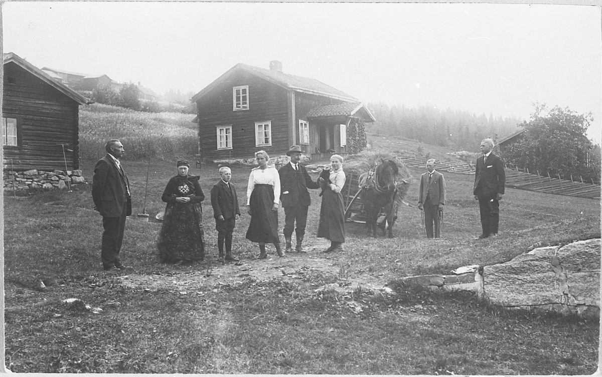 Gardstun. Øvre Grønhovd (nedre delen), rundt 1920. Gruppe av pent kledde mennesker, blant dem ei kvinne i "fjelldrakt". Hest med høyvogn. 