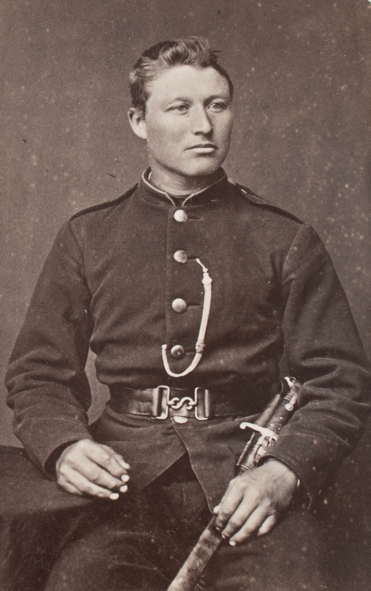 Portrettfotografi av en mann med uniform i fotoatelier.