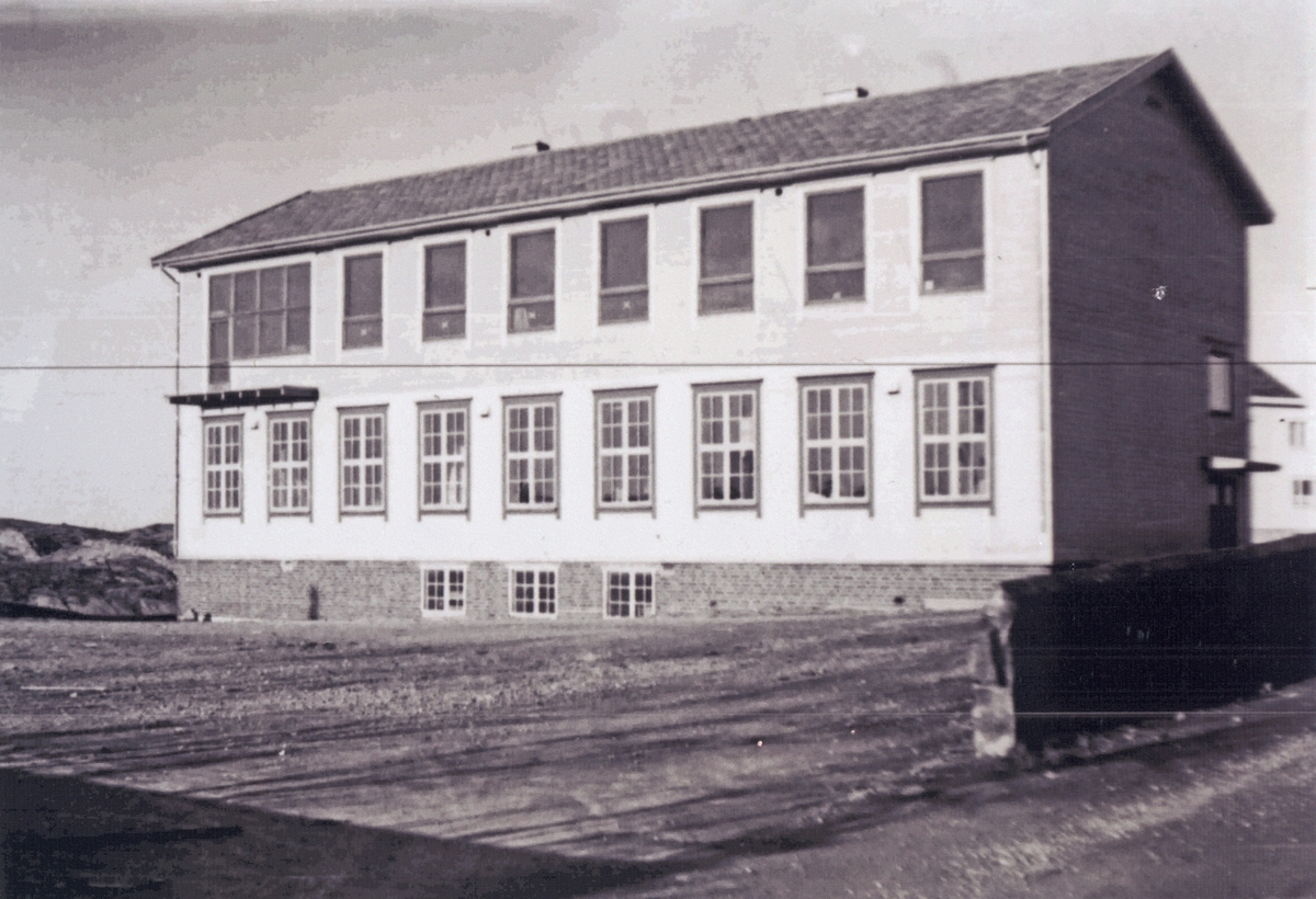 Sævland skole. Større bygning i to etasjer på en åpen plass. Bygget 1932.