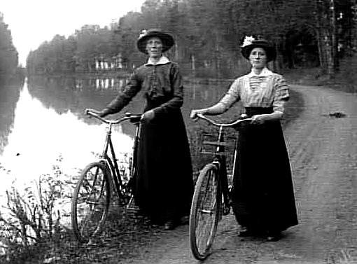 Cyklande kvinnor på kanalbanken