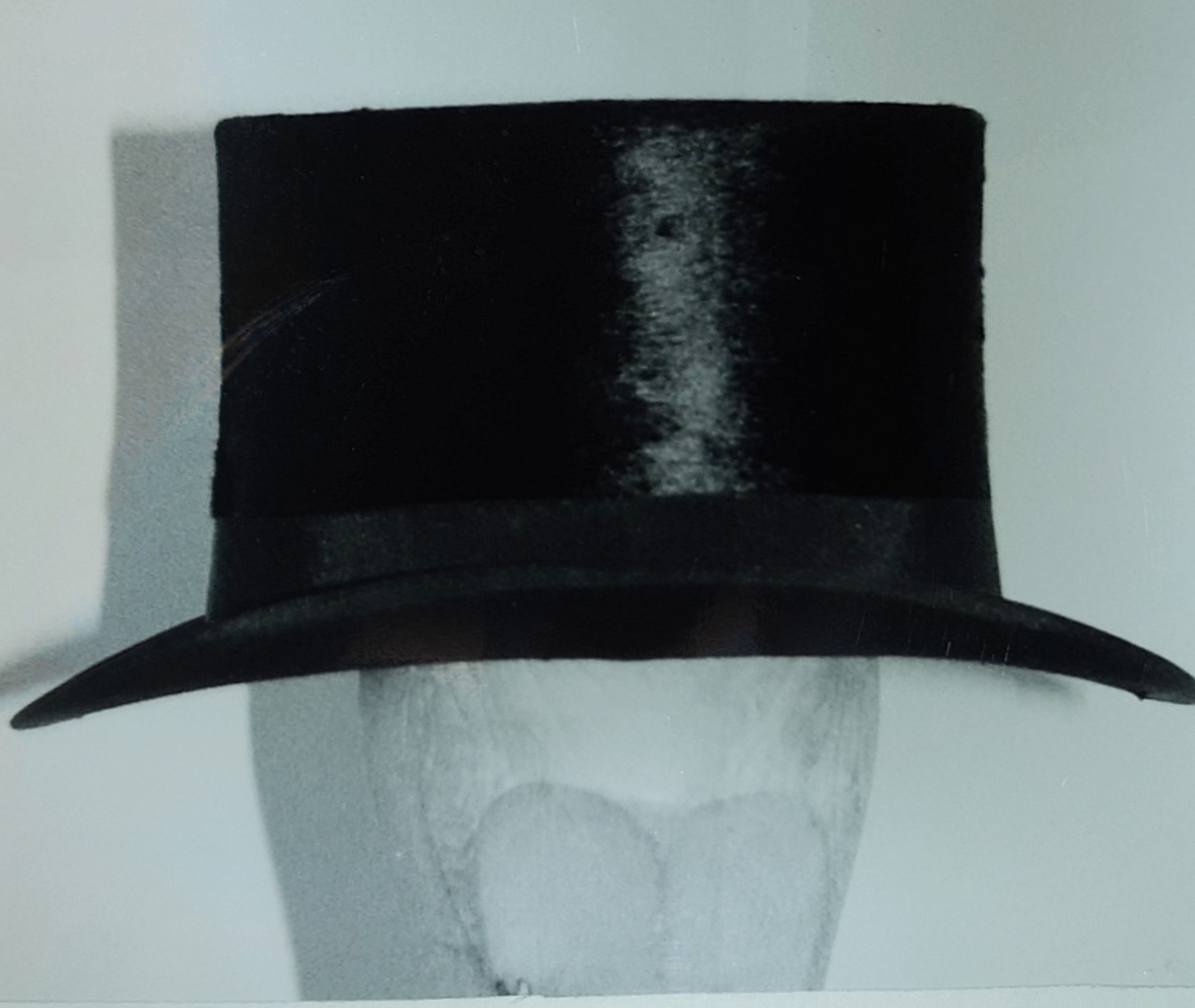 A: Hattekoffert; grågrønn m/lærremmer og håndtak (B): Sort flosshatt