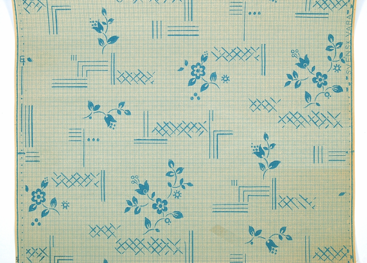 Stiliserade blommor och geometriska ornament i turkosblått på ett ofärgat papper. Övertryck med rutmönster. Art Déco/Funktionalism.