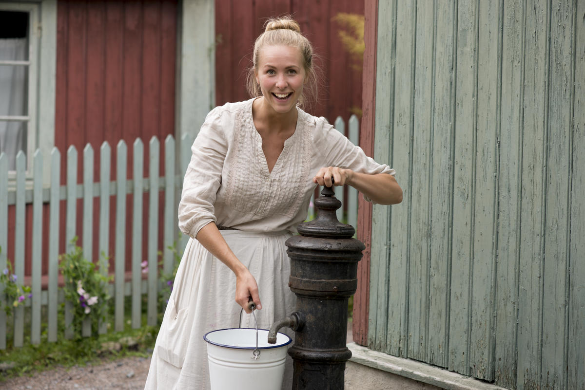 Husmor på Enerhaugen henter vann ved vannposten (Foto/Photo)