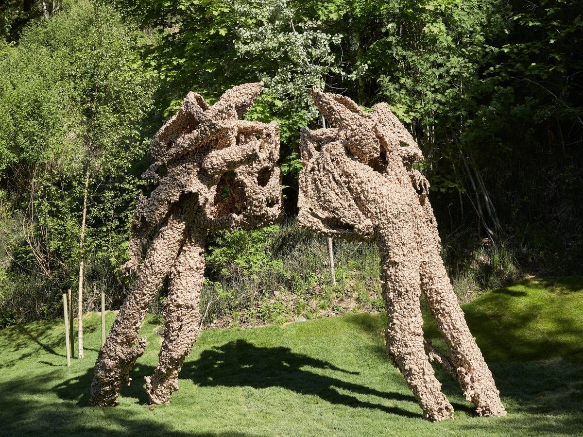 To "figurer", begge på ca. 450 cm, som står mot hverandre i en type "face off". Abstrakte former. Ujevn overflate på begge figurene.